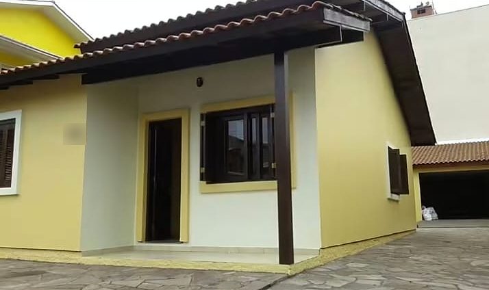Casa térrea com fachada pintada em amarelo e branco